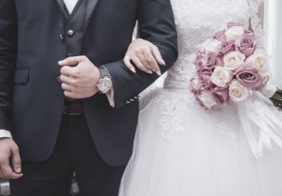 身穿婚紗的新娘和新郎手牽手，體驗婚禮顧問的情感支持和指導。